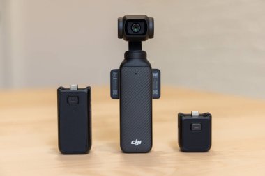 Bishkek, Kırgızistan - 4 Kasım 2024: DJI Battery Sapı, 1 / 4 iplik ve DJI Osmo Pocket 3 tahta bir masaya yerleştirilmiş