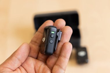 Bişkek, Kırgızistan - 4 Kasım 2024: Görünür denetim ve göstergelere sahip el bilgisayarı DJI MIC 2 vericisinin yan görünümü, işlevselliği vurguluyor