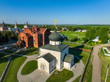 Bir hava görüntüsü Yuryev Polsky 'nin tarihi kiliselerini gösteriyor. Açık mavi gökyüzünün altında yemyeşil manzaralarla çevrili.