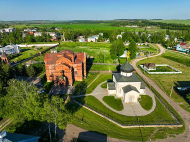 Yuryev Polsky 'deki tarihi kiliseleri gözler önüne seren hava manzarası, yeşil alanlar ve açık mavi bir gökyüzü üzerine kurulmuş.