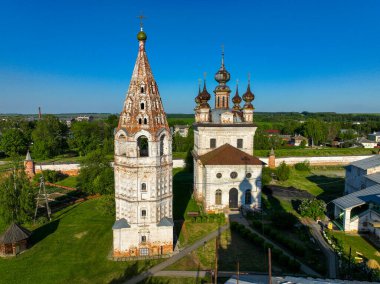 Yuryev Polsky, Rusya 'daki iki tarihi kilise, açık mavi gökyüzü altında karmaşık mimari ayrıntılar ve süslü kubbeler barındırıyor.