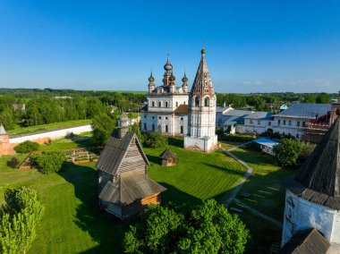 Rusya 'nın Yuryev Polsky manastırı içinde tarihi kiliseler, geleneksel ahşap bir yapı ve yemyeşil çimenler yer alıyor.