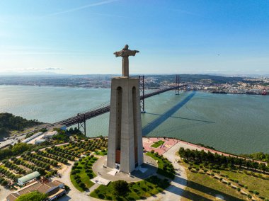 Almada, Portekiz - 14 Mayıs 2024: Kral Anıtı Tagus Nehri ve ikonik asma köprü manzaralı yüksek bir açıdan görülüyor