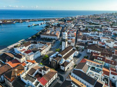 Arka planında kırmızı çatıları, yeşilliği ve manzaralı tepeleri olan Ponta Delgada 'nın yerleşim bölgesi.