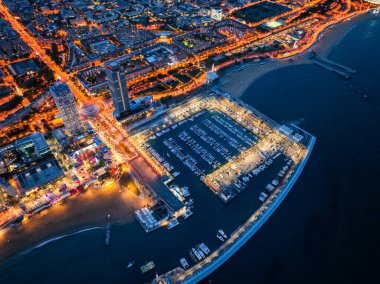 Olimpik Limanı ve sahil boyunca uzanan şehir ışıklarının gece görüş alanında.