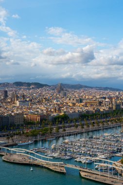 Barcelona, İspanya - 12 Mayıs 2023: Yatlı Port Vell marinasının geniş hava manzarası ve arka planda şehir silüeti