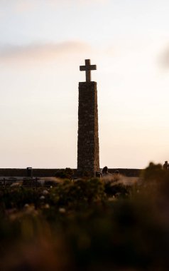 Cabo da Roca, Portekiz - 12 Mayıs 2024: Günbatımı gökyüzünün altında haçlı taş sütun