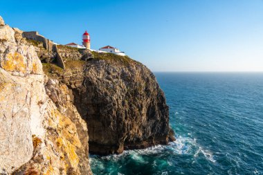 Cabo da Roca deniz feneri açık bir günde geniş Atlantik Okyanusu ve kıvrımlı sahil şeridine bakan yüksek ve engebeli bir uçuruma tünemiştir.