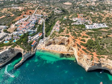 Carvoeiro 'daki resim plajı uçurumlar ve kasaba binalarıyla çevrili.