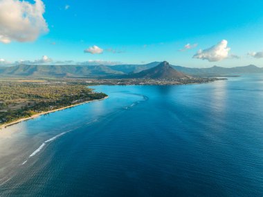 Plajı, kıyı kasabasını ve Flic en Flac 'da gün batımında dağları geniş bir açıdan görebiliriz.