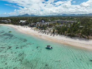 Mauritius 'taki temiz sığ sularla tropikal sahil otelinin havadan çekilmiş görüntüsü.