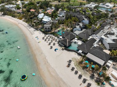 Sahildeki tatil köyü, canlı deniz manzarası ve otel kompleksi.