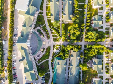 Balykchy, Kırgızistan - 12 Mayıs 2023: Ana bina, kır evleri, peyzaj bahçeleri ve dolambaçlı yolların yer aldığı bir tatil köyünün tepeden aşağı havadan görünüşü