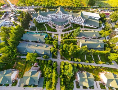 Balykchy, Kırgızistan - 12 Mayıs 2023: Büyük ana binayı ve manzaralı bahçeler ve kaldırımlarla birbirine bağlı küçük kulübelerin yer aldığı bir tatil beldesinin havadan görünüşü