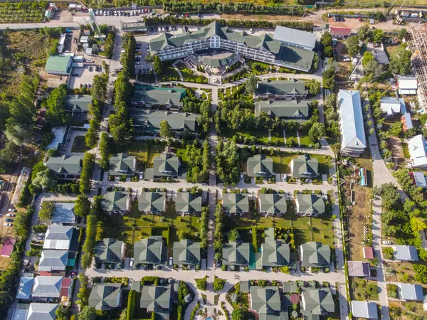 Balykchy, Kırgızistan - 12 Mayıs 2023: Sayısız kır evi, bir ana otel binası ve iyi korunmuş yeşil alanlar içeren tepeden tırnağa bir tatil köyü manzarası