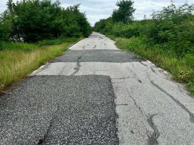 Damaged road surface with cracks and potholes. Realistic infrastructure problem for urban planning, safety awareness, or construction-related design