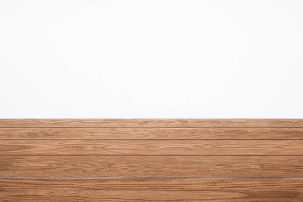 Пустой деревянный пол с белым фоном стены, идеально подходит для демонстрации продукции, макетов или презентаций дизайна. Минималистская и чистая концепция интерьера.