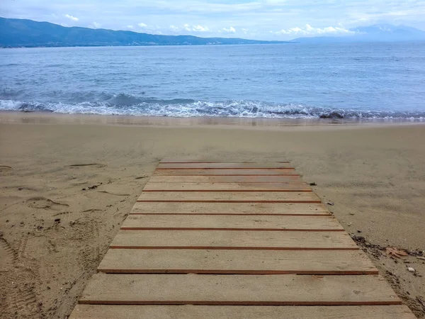 Kumsala giden yol mavi deniz ve bulutlarla dolu..