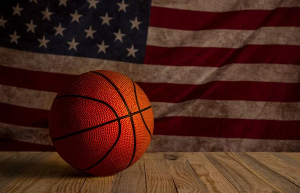 Basketball with vintage United States of America flag in the background - table view with copy space.