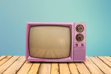 Ofis masasında mavi pankartı olan klasik pembe televizyon..
