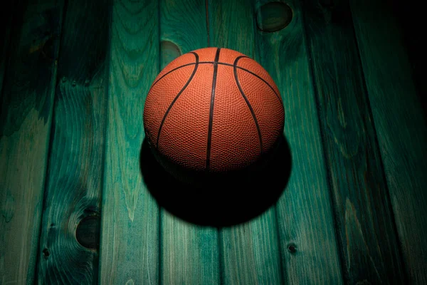Basketbal Izolovaný Zeleném Dřevěném Stole Světlem Shora — Stock fotografie