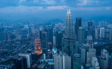 Kuala Lumpur Şehir Gökdelenleri gün batımından sonra Petronas kuleleri görünürde.