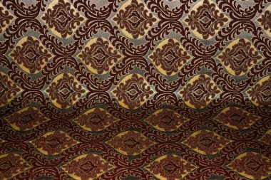 Kumaş deseni kahverengi arkaplanı kapatıyor.