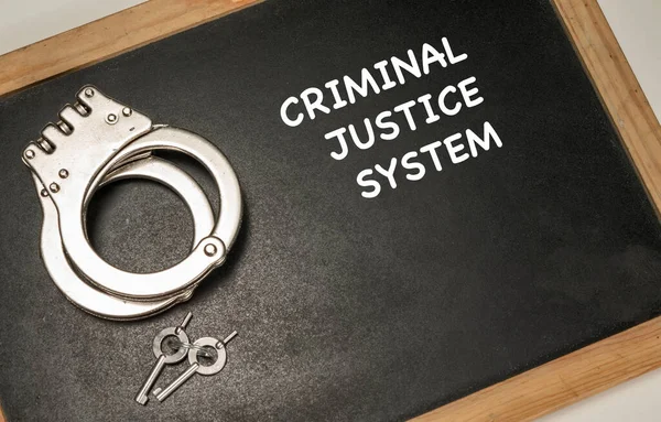 Criminal justice system text with handcuff and keys.