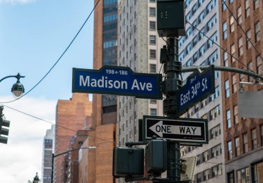 Madison Ave Street sign with New York City buildings in background. clipart