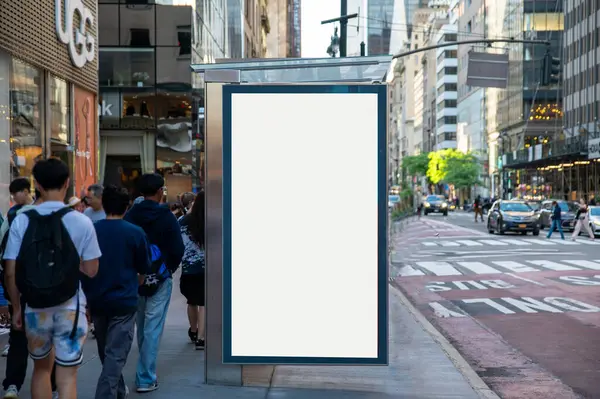 New York 'taki otobüs durağında dikey beyaz ilan panosu modeli. Arka planda binalar ve yol.