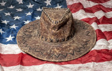 Arka planda Birleşik Devletler Bayrağı olan klasik kahverengi şapka.