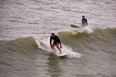 Kışın Ccoa Sahili İskelesinde sörf yapmak