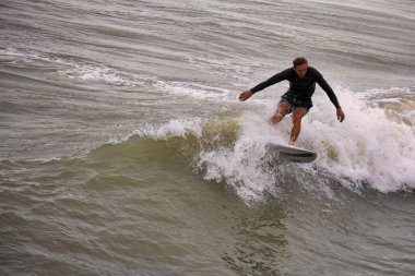 Kışın Ccoa Sahili İskelesinde sörf yapmak