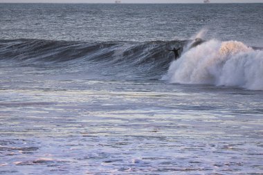 Surfing Giant waves on West Beach in Santa Barbara