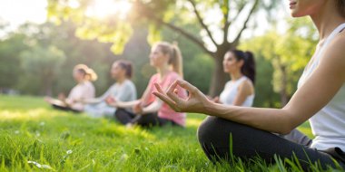 Zihinsel durumların geçmişi. Bir grup insan sabahları doğanın ortasında dinlenmek ve dikkatli bir terapi için parkta meditasyon ya da yoga yapıyor.