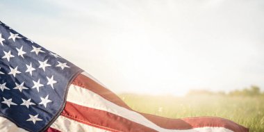 Anma Günü Arkaplanı. Anma Günü 'nde barışı anma konseptinde sabah güneşinin olduğu bir alanın arka planında Amerikan bayrağı