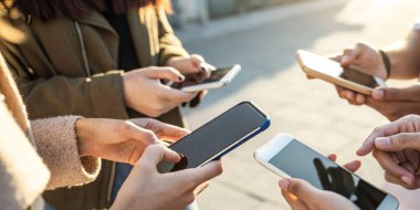 Mobil internet ve kullanışlı ve hızlı takım çalışması yoluyla iletişim kavramında akıllı telefon kullanan bir grup insan