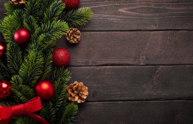 Noel süslemeleri köknar dalları, Noel topları ve kahverengi tahta koniler, fotokopi alanı ile üst manzara