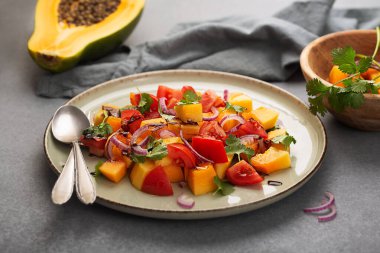 Domatesli papaya salatası, roka, kırmızı soğan ve balzamik sirke. Kapat.