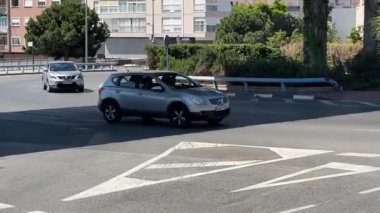 Alicante, İspanya - 29 Mayıs 2025: Sakin sokaklar ve açık hava gösteren bir araba, şehir ortamında virajlı bir yolda ilerliyor. Alan pürüzsüz sürüş için tasarlandı..