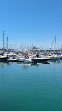 Alicante, İspanya - 29 Mayıs 2025: Değişik yat ve teknelerle dolu canlı bir marina, parlak mavi bir gökyüzünün altında sakince oturur. Huzurlu su hareketli bir liman bölgesinde güzel bir manzara yaratır..