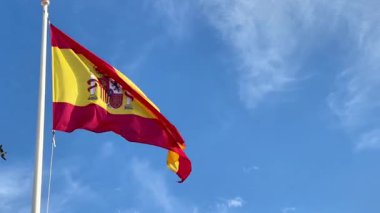 Alicante, İspanya - 3 Haziran 2025: Ulusal gurur ve kültürel kimliği temsil eden açık mavi gökyüzüne karşı İspanya bayrağı dalgalanır