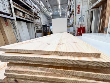 Alicante, İspanya - 18 Haziran 2025: Ahşap kalaslar iyi aydınlatılmış bir hırdavatçı koridorunda, çeşitli projeler için doğal güzelliklerini ve çok yönlülülülüklerini vurguluyorlar.