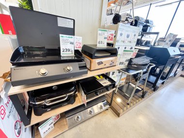 Alicante, İspanya - 18 Haziran 2025: Perakende satış mağazasında çeşitli açık hava ızgaraları ve barbeküler sergileniyor, modern yemek aletleri ve tanıtım fiyatlandırmaları vurgulanıyor