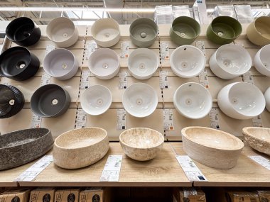 Alicante, İspanya - 18 Haziran 2025: Seramik kaselerin çeşitli renk ve dokularda sergilenmesi, bir ev eşyaları mağazasının raflarında düzgünce düzenlenmiştir