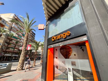 Alicante, İspanya - 24 Haziran 2025: Palmiye ağaçlarıyla birlikte şehirde portakal dükkanı, yoldan geçenler için canlı bir alışveriş ortamı yaratıyor