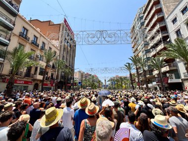 Alicante, İspanya - 24 Haziran 2025: Kalabalık bir kalabalık kalabalık kalabalık kalabalık bir şehirde güneşli bir günün tadını çıkarıyor ve neşeli bir ortam yaratıyor.