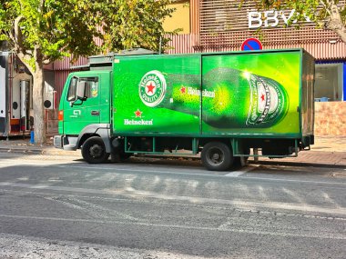 Alicante, İspanya - 24 Haziran 2025: Heineken dağıtım kamyonu şehir sokağına park edildi, parlak yeşil markalaşma ve logo, ticari kullanım için mükemmel