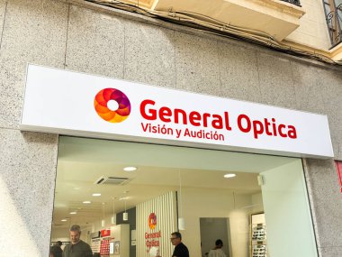 Alicante, İspanya - 24 Haziran 2025: Genel Optica mağazası önü parlak tabela ve çağdaş tasarım içeriyor, vizyon ve işitme ihtiyaçları için müşteri çekiyor