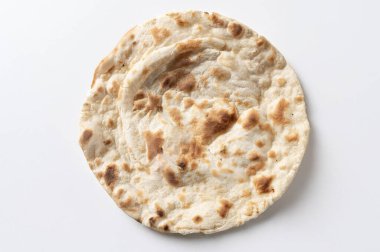  Geleneksel Hint naan ekmeğine yakın plan, beyaz arka planda izole edilmiş un, su, maya ve yoğurttan yapılmış yumuşak bir ekmek. Altın-kahverengi, desenli yüzey, yukarıdan görünüyor..